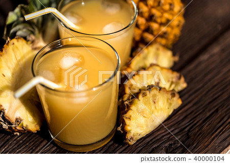 Pineapple juice and slice placed on a wooden table 40000104