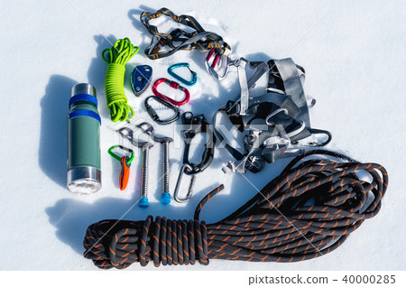 Close-up of winter climbing equipment on fresh snow on a sunny day. Carbines with a rope gazebo and Close-up of winter climbing equipment on fresh snow on a sunny day. Carbines with a rope gazebo and 40000285