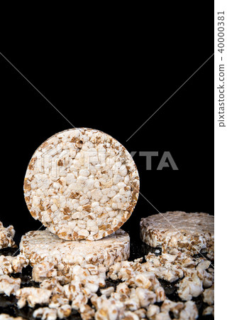 Wheat grain crispbread on black, diet, in low key Wheat grain crispbread on black, diet, in low key 40000381