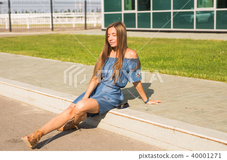Girl sitting on street in summer day Girl sitting on street in summer day 40001271