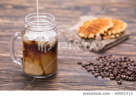 Milk is poured into coffee Milk is poured into coffee 40001313