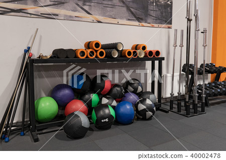 Fitness balls and rods on floor in gym for workout 40002478
