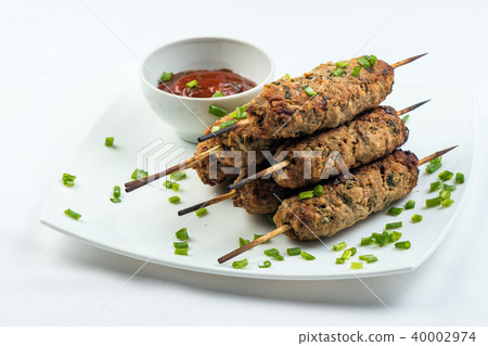 kebab with herbs on a white plate on a white background kebab with herbs on a white plate on a white background 40002974