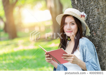 Beautiful Asian woman reading pink book Beautiful Asian woman reading pink book 40009001