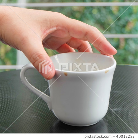 Hand Holding Empty Cup of Coffee on The Table 40012252