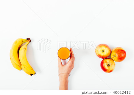 Female hand holding orange juice glass 40012412