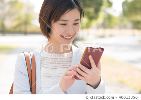 Young business woman looking at a smartphone outdoors 40013350