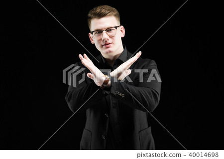 Portrait of confident handsome elegant responsible businessman showing stop gesture on black Portrait of confident handsome elegant responsible businessman showing stop gesture on black 40014698