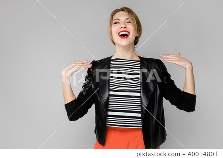 Attractive young blonde girl in striped blouse and leather jacket smiling laughing showing on Attractive young blonde girl in striped blouse and leather jacket smiling laughing showing on 40014801