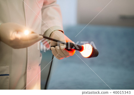 Proctologist holding an anoscope. In the hospital Proctologist holding an anoscope. In the hospital 40015343