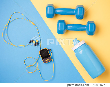 Photo of player, dumbbells, bottle of water on blue and yellow background 40018748