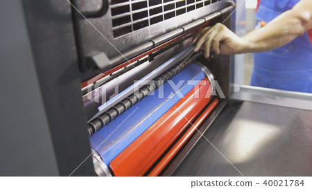 Worker puts the plate in the press print machine 40021784