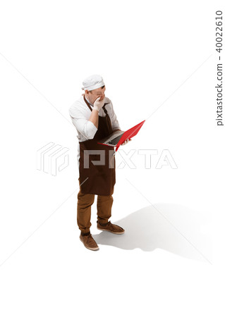Serious butcher posing with a laptop isolated on white background Serious butcher posing with a laptop isolated on white background 40022610