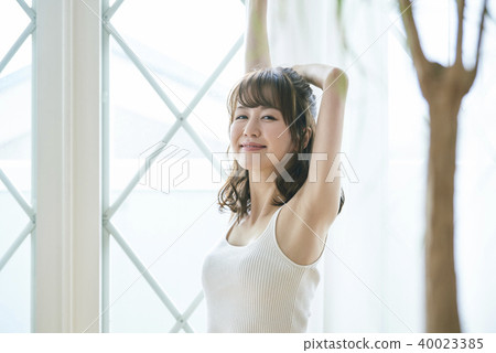 A woman stretching at the window 40023385
