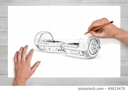 Male hands drawing a gyroscooter with a pencil on a large piece of paper. 40023478