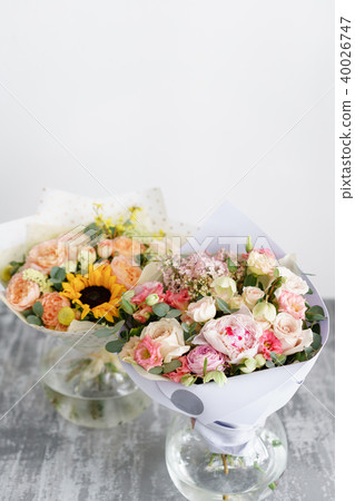two bouquet of beautiful flowers on gray table. Floristry concept. Spring colors. the work of the 40026747