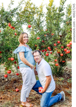 Portrait of happy family in the pomegrate garden. 40027245