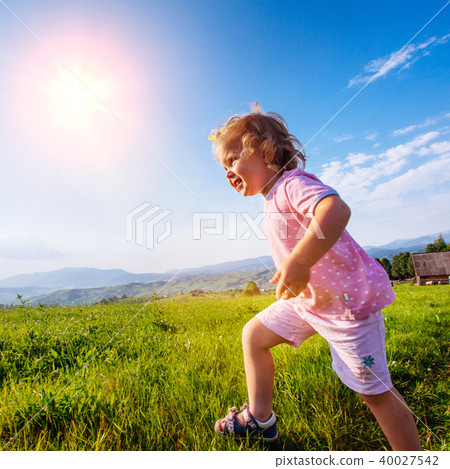 little girl runs through a beautiful meadow little girl runs through a beautiful meadow 40027542