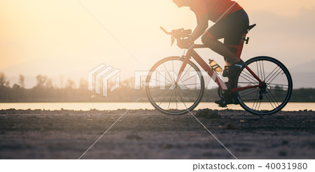 A cyclist riding a road bike on road in the moring A cyclist riding a road bike on road in the moring 40031980