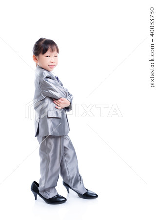 Little girl wearing suit and big high heel shoes Stock Photo