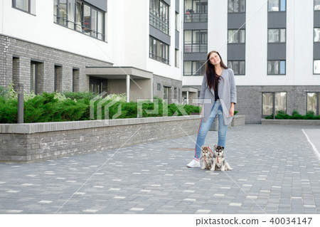 Young attractive women walking with two husky puppy on the street 40034147