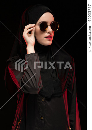 Portrait of beautiful stylish young muslim woman wearing black hijab and sunglasses as modern 40035727