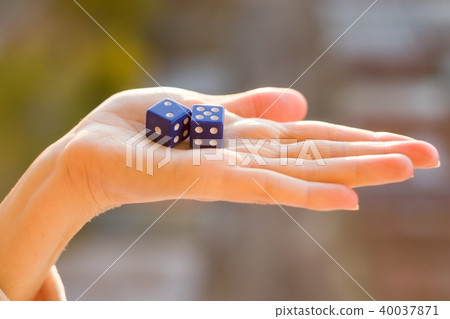 Dice 2 5 in the female hand, sunset background. Dice 2 5 in the female hand, sunset background. 40037871