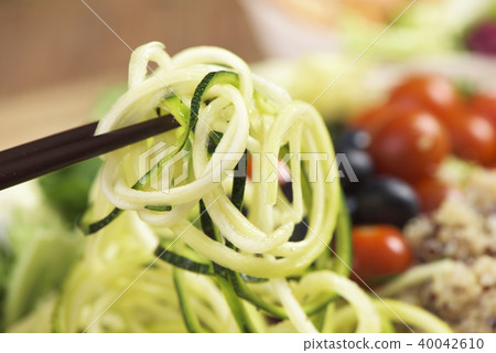picking zucchini from a buddha bowl 40042610