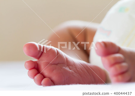 Newborn baby infant feet on white bed 40044437
