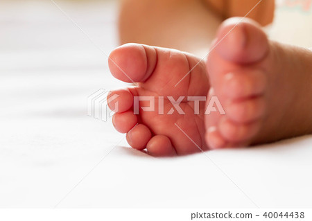 Newborn baby infant feet on white bed Newborn baby infant feet on white bed 40044438