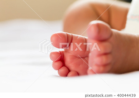 Newborn baby infant feet on white bed Newborn baby infant feet on white bed 40044439