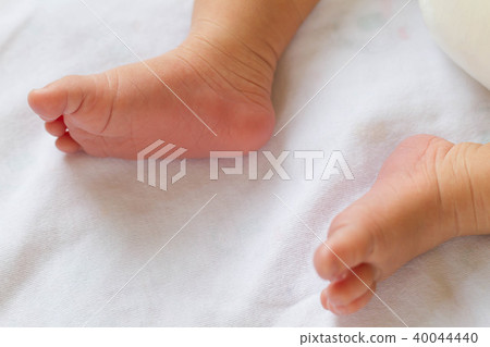 Newborn baby infant feet on white bed Newborn baby infant feet on white bed 40044440