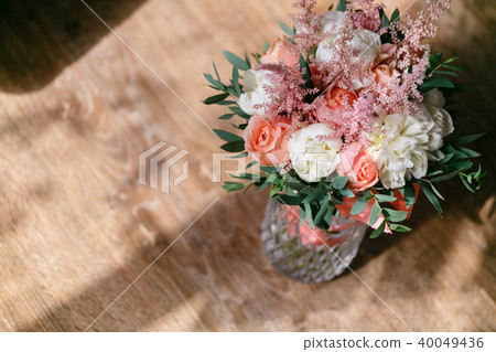 Wedding bouquet of white peony and pink roses wooden table. Lots of greenery, modern asymmetrical Wedding bouquet of white peony and pink roses wooden table. Lots of greenery, modern asymmetrical 40049436