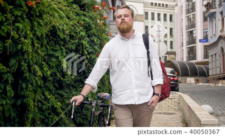 Portrait of stylish man walking to work with bicycle Portrait of stylish man walking to work with bicycle 40050367