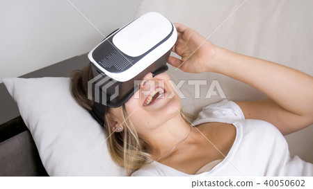 Portrait of happy laughing woman wearing VR headset Portrait of happy laughing woman wearing VR headset 40050602
