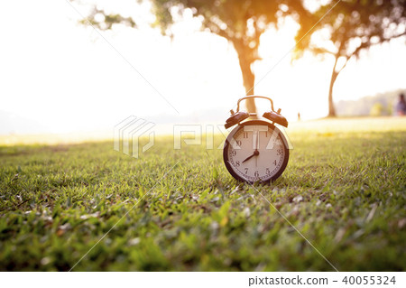 Retro alarm clock placed on green 40055324