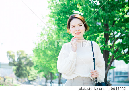 Woman walking along a tree-lined road 40055632