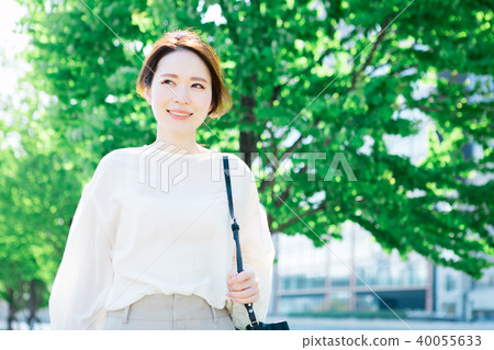 Woman walking along a tree-lined road 40055633