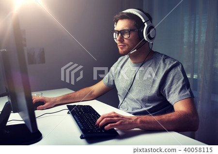 man in headset playing computer video game at home man in headset playing computer video game at home 40058115
