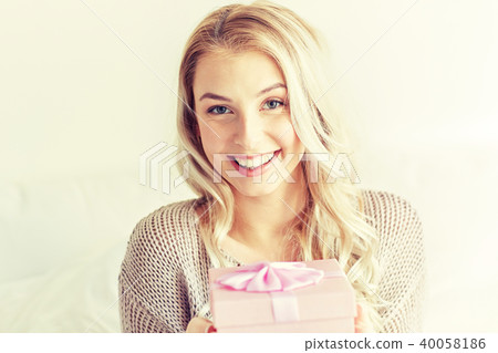 happy young woman with gift box at home 40058186