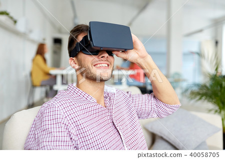 happy man with virtual reality headset at office 40058705
