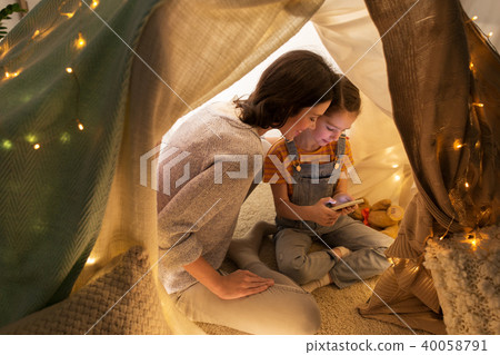 happy family with smartphone in kids tent at home 40058791