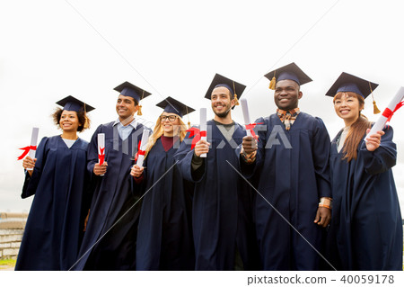 happy students in mortar boards with diplomas 40059178