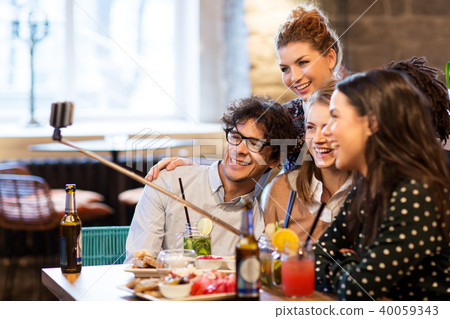friends taking selfie by smartphone at bar or cafe 40059343