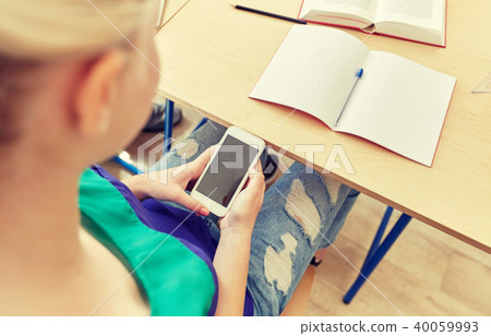 student girl with smartphone texting at school 40059993