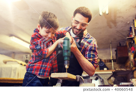 father and son with drill working at workshop father and son with drill working at workshop 40060548