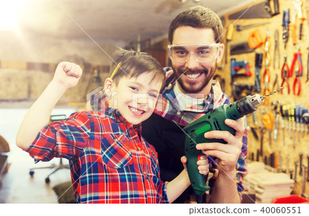 father and son with drill working at workshop father and son with drill working at workshop 40060551