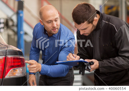 mechanic and customer looking at car taillight mechanic and customer looking at car taillight 40060554