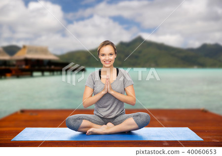 woman making yoga in and meditating lotus pose 40060653
