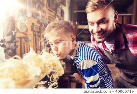 father and little son with wood plank at workshop 40060719
